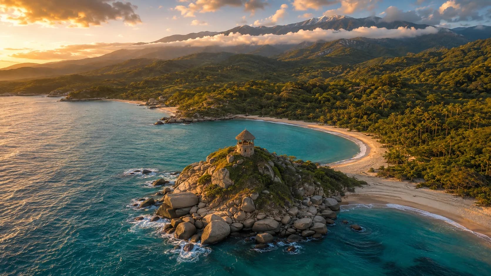 Vista aérea de Cabo San Juan del Guía, en el Parque Tayrona: dos bahías de arena separadas por un promontorio de rocas de granito, con las crestas de la Sierra Nevada de Santa Marta al fondo.